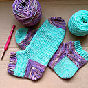 Une pelote de turquoise et une pelote de violet chiné suffisent pour réaliser cette paire de chaussettes uniques.