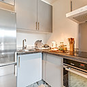 La cuisine en gris et inox a été aménagée dans l’ancienne entrée.