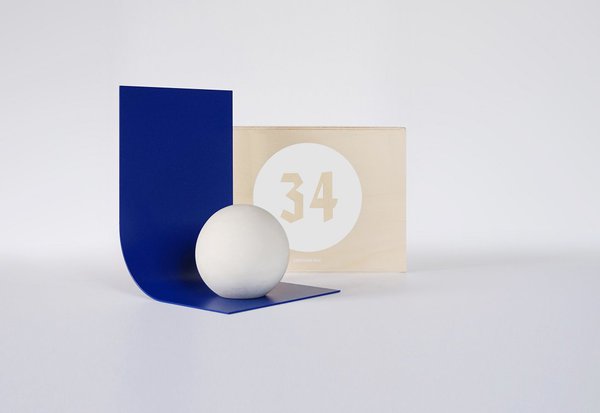 Designerbox n° 34 : Serre-livre Murakami en béton et aluminium laqué bleu (L 15 x P 1,5 x H 20 cm). Création Studio Dessuant Bone.