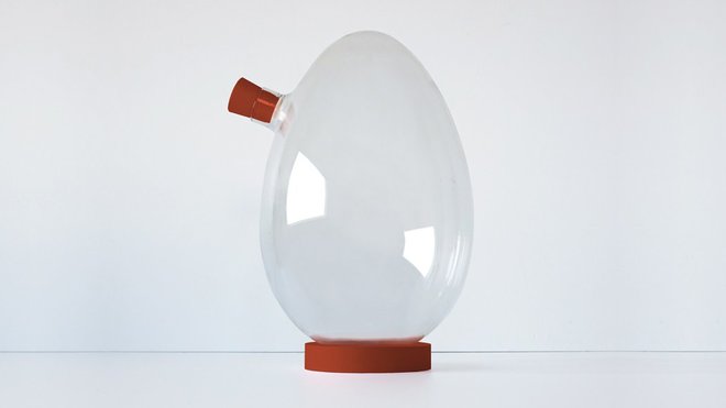 Carafe à alcool Egg en verre soufflé bouche et silicone de couleur brique (diamètre 15 x H 22,5cm). Création Sébastian Bergne, gamme Iconic Serie.