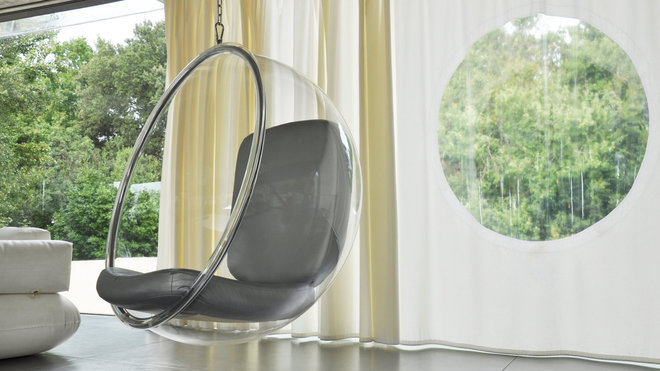 Le fauteuil bulle d’Eero Aarnio suspendu dans l’espace dialogue avec l’oculus de Petra Baisse, dessiné dans un rideau de plastique blanc. Le fauteuil bulle d’Eero Aarnio suspendu dans l’espace dialogue avec l’oculus de Petra Baisse, dessiné dans un rideau de plastique blanc.