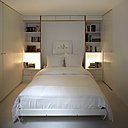 Unité inférieure à deux niveaux. A gauche, placards de stockage et rangements du souplex. A droite, la chambre du souplex équipé d’un lit rabattable contre le mur. Pour le sous-sol, le studio d’architecture Pan a construit une sorte de boîte dans une boîte, le volume initial. Et il a installé une ventilation mécanique pour le rendre habitable. Unité inférieure à deux niveaux. A gauche, placards de stockage et rangements du souplex. A droite, la chambre du souplex équipé d’un lit rabattable contre le mur. Pour le sous-sol, le studio d’architecture Pan a construit une sorte de boîte dans une boîte, le volume initial. Et il a installé une ventilation mécanique pour le rendre habitable.