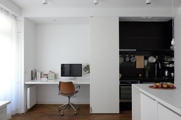 Unité inférieure à deux niveaux. Dans l’unité inférieure, le premier bureau, avec plan de travail fixe, est situé en continuité du mur de la cuisine qui se cache dans un placard.