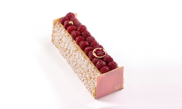 La Bûche Tropézienne légendaire avec un insert aux framboises posé sur la brioche.