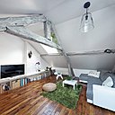 Dans le séjour, le parquet d’origine conservé a été poncé et vitrifié. Canapé convertible, modèle Toast, Conforama. Coussins en laine blanc, Ikea. Tapis, Heytens. Pouf rond en fibres de banane, modèle Alseda, Ikea. Siège chien Me too Puppy_design by Eero Aarnio. Radiateur faible hauteur, modèle Bellagio, pour plinthe, chez Noirot (L 133 x H 30 x P 14 cm).