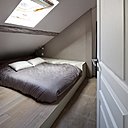 La chambre est meublée d’un lit coffer (3 Suisses) intégré dans l’estrade. D’autres coffres sur mesure sont recouverts de cuir blanc crème et suédine beige rosé.