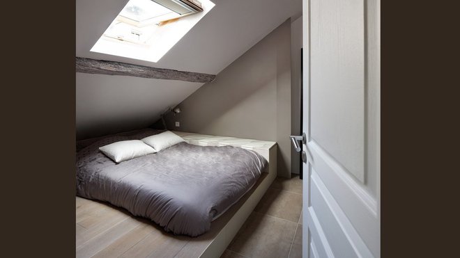 La chambre est meublée d’un lit coffer (3 Suisses) intégré dans l’estrade. D’autres coffres sur mesure sont recouverts de cuir blanc crème et suédine beige rosé.