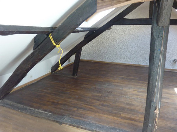 Avant les travaux: le plancher et les poutres noircies assombrissaient l’espace ne mettaient pas en valeur le grand plateau du séjour.