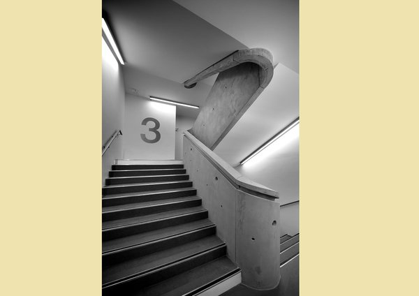 A l’intérieur, un grand escalier dessert tous les étages. Le béton brut, hommage au style de René Egger, est seulement protégé par un vernis transparent.