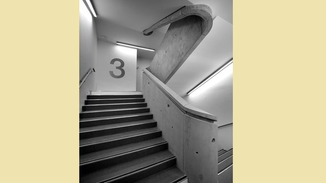 A l’intérieur, un grand escalier dessert tous les étages. Le béton brut, hommage au style de René Egger, est seulement protégé par un vernis transparent.