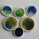 Boutons avec décor en verre de récupération fondu à la cuisson qui dessine une sorte de mosaïque solidaire du support en porcelaine. Création Caroline Worner.