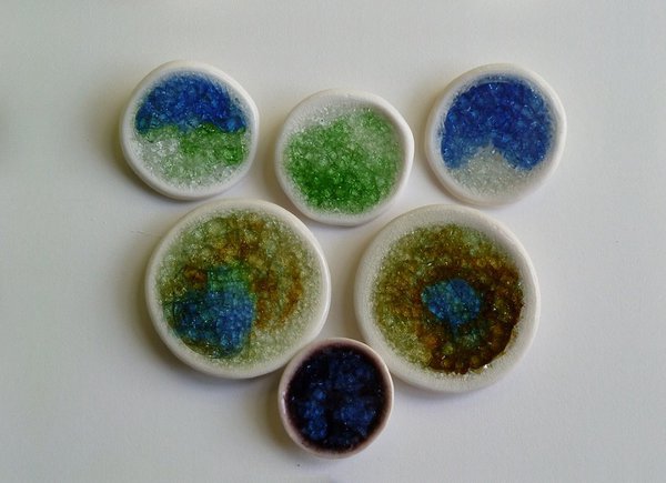 Boutons avec décor en verre de récupération fondu à la cuisson qui dessine une sorte de mosaïque solidaire du support en porcelaine. Création Caroline Worner.