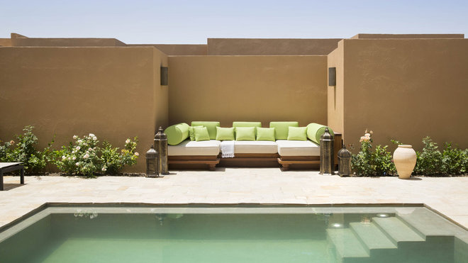 Autour de la piscine privée, les hauts murs dessinent des patios.