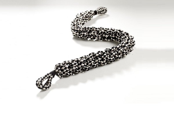 Bicolore. Cette petite tresse à deux côtés, ou soutache, séduira les tapissiers les plus audacieux pour orner coussin ou fauteuils, Dedar.