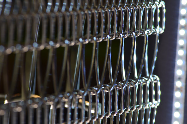 Gros plan sur une résille spiralée composée d’un alliage de mailles de différentes dimensions reliées entre elles. Modèle Torroja laminée mixée, création Maillemétal design.