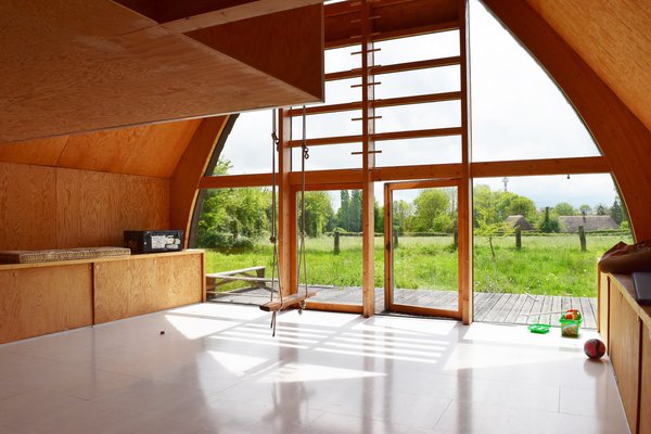 Au milieu du salon, une balançoire aux cordes directement vissées sur la structure accentue la sensation de vivre à l’extérieur, au milieu d’un champ.