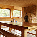 Dans la cuisine et l’espace repas meublé avec une grande table de ferme, le chauffage est assuré par un four à bois en brique.