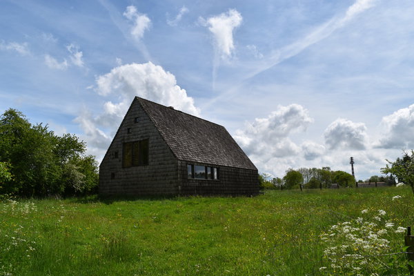 La maison posée sur des plots en béton offre une emprise réduite au sol. Elle a été fabriquée en sapin du Nord, bardeaux de cèdre rouge et sapin du Nord brûlé.