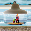 Dans une suspension lumineuse éditée par ENO (modèle Favourite things, création Chen Karlsson) personnages en pâte à modeler avec les pieds dans le sable.