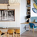 Un petit coin lecture devant un mur recouvert de lambris repeints en blanc et le coin réservé aux handicapés avec une tablette à la bonne hauteur.