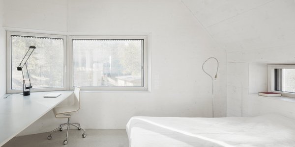 La chambre immaculée intègre un coin bureau avec un plateau inséré dans la maçonnerie sous les fenêtres.