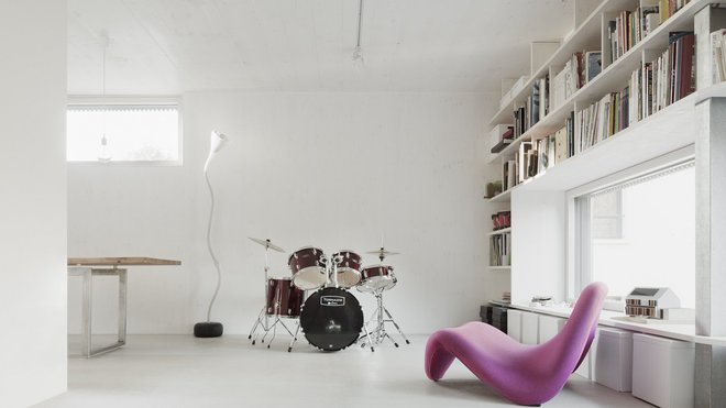 Un salon pour faire de la musique et qui intègre une bibliothèque et des rangements qui encadrent la fenêtre pour libérer de l’espace au sol. Un salon pour faire de la musique et qui intègre une bibliothèque et des rangements qui encadrent la fenêtre pour libérer de l’espace au sol.