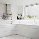 La cuisine toute de blanc vêtue et au-dessus de la cheminée des étagères ouvertes pour le rangement de la vaisselle. La cuisine toute de blanc vêtue et au-dessus de la cheminée des étagères ouvertes pour le rangement de la vaisselle.