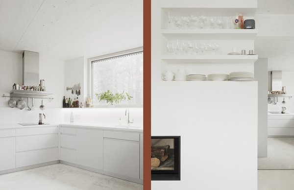 La cuisine toute de blanc vêtue et au-dessus de la cheminée des étagères ouvertes pour le rangement de la vaisselle.