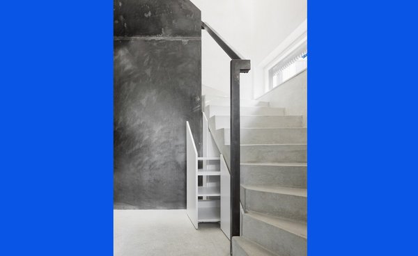 Sous les marches de l’escalier en béton, un rangement coulissant pour gagner de la place.