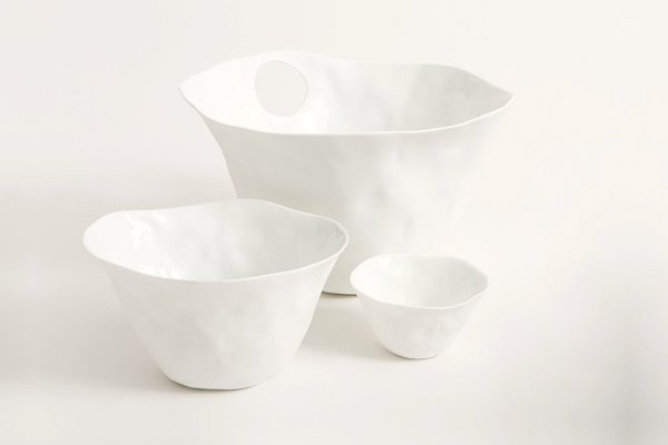 Moho, série de 3 contenants aux matières contrastées par une porcelaine émaillée à l’intérieur et laissée en biscuit brut à l’extérieur avec des détails de façonnage. Les perçages servent à les saisir ou à glisser des couverts fins de service ou des baguettes. En porcelaine blanche de Limoges. Création Isabelle Poupinel.