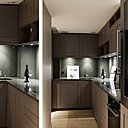 Les rangements de la cuisine (Perene) sont en bois peint avec veine du bois visible. La crédence et le plan de travail sont en Pierre de Plan. Au sol, un parquet en chêne à lames larges couleur bois flotté recouvert d’un vernis mat (Panaget).