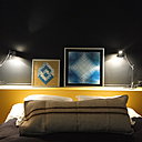 Dans la même chambre, ambiance différente et plus graphique avec des œuvres encadrées de Vasarely et un gros coussin en lin brut animé d’une rayure tissée.