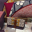 Coussins et pochettes aux assemblages de tissus lumineux.