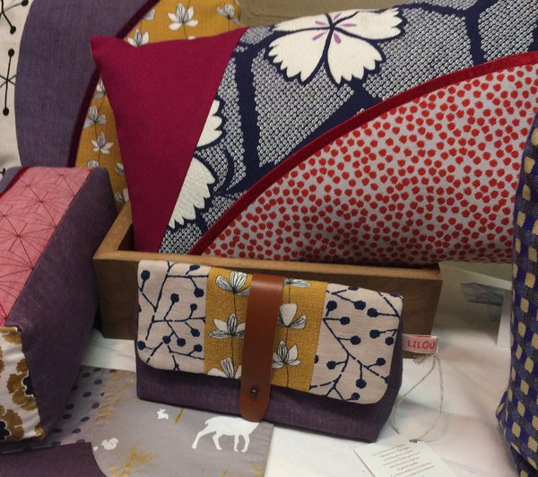 Coussins et pochettes aux assemblages de tissus lumineux.