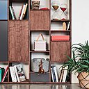 Gros plan sur une grande bibliothèque avec façades en placage de noyer et touches de couleurs très actuelles. L’ensemble, 1166 €.