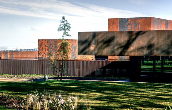 Avec la lumière, la façade principale du musée Soulages fait varier les nuances de l’acier Corten dont la corrosion est utilisée pour son aspect brut et ses qualités de résistance aux conditions atmosphériques.