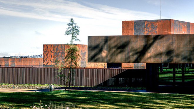 Avec la lumière, la façade principale du musée Soulages fait varier les nuances de l’acier Corten dont la corrosion est utilisée pour son aspect brut et ses qualités de résistance aux conditions atmosphériques.