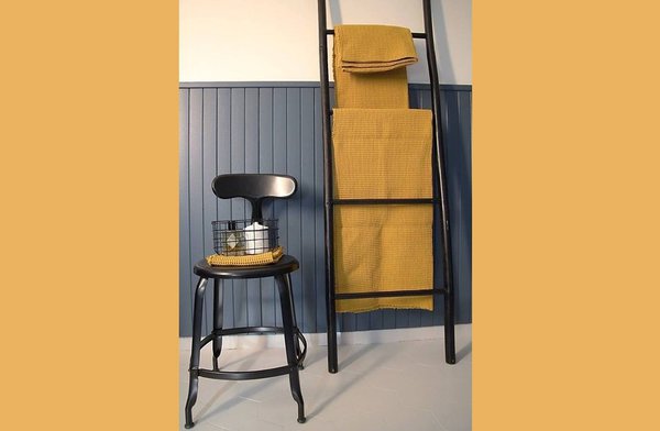 Ambiance moutarde et noire pour la salle de bains et les serviettes en nid d'abeille.