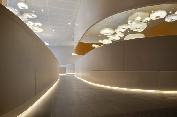 Les éclairages aux formes organiques dessinent un ciel de nuages, en référence au nom du centre d’affaires : Cloud Business Center.