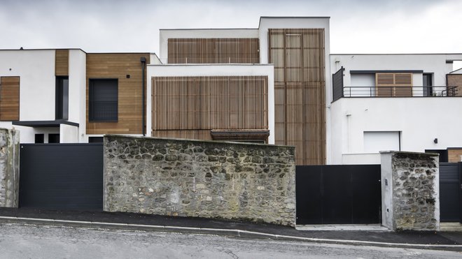 Au nord, le même dispositif de volets est intégré au niveau de l’entrée et permet en position ouverte d’abriter le seuil de l’entrée et quand il est fermé de sécuriser la maison. Réalisation de DDA Architectes, à Meudon.