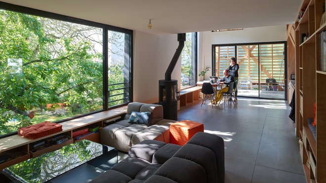 Dans cette maison sur pilotis, toutes les pièces principales de la maison sont tournées vers le jardin, les arbres et le canal, donnant l’impression de vivre au plus près de la nature, comme perché dans un nid. Réalisation MNM Architectes, à Rennes.