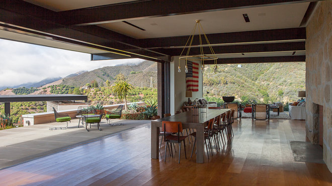 Pour l’ancrer au mieux dans son décor naturel, les façades de la maison sont rythmées par des murs en béton épais dans des tonalités qui rappellent le brun et le rouge de la terre, par des bardages en bois d’Alaska.