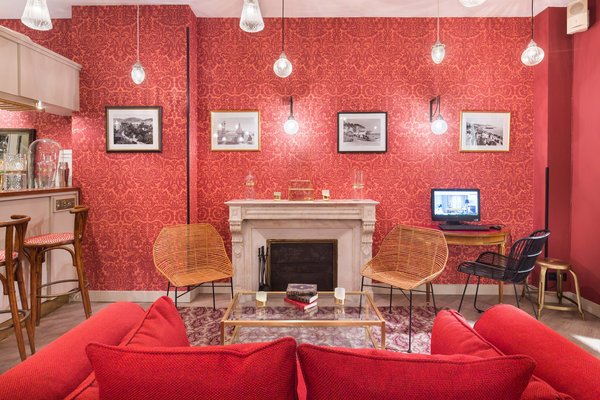 Le hall d’entrée a conservé son écrin classique avec sa traditionnelle cheminée en marbre. Des anciennes photos noir et blanc du pays niçois apportent une touche de nostalgie.