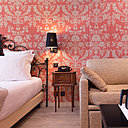 Dans cette suite et chambre supérieure (25 à 30 m²), le rose est mis avec un camaïeu de tons poudrés et tendres. Papier-peint motif St Antoine chez Farrow and Ball.