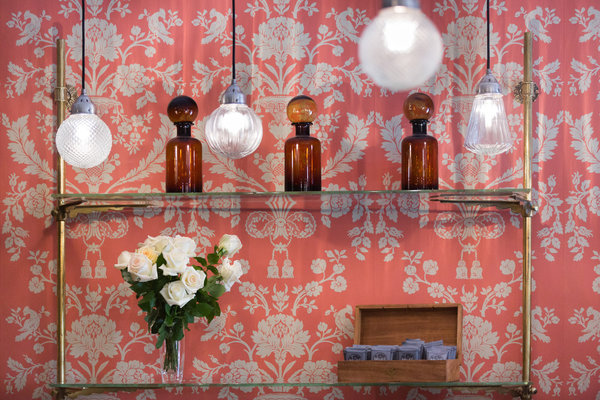 Un petit air de brocante pour ces flacons façon boutique d’apothicaire sur un dressoir chiné avec étagères en verre et structure en laiton.