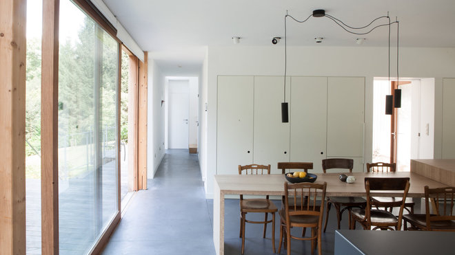 La table de repas s’articule en angle avec un premier plateau comptoir qui sert pour le petit déjeuner. Son biseau s’aligne sur le joint de dilatation du sol en béton et au niveau des autres meubles de rangements pour dégager un couloir et dégagement latéral. Au sol, le béton offre des joints de dilatation tous les 25 m² qui empêchent ce revêtement de se fissurer.