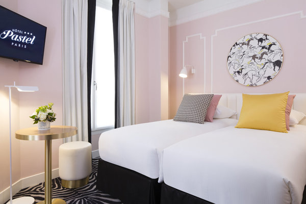 Un papier-peint signé d’une grande maison de luxe Parisienne est encerclé dans un cadre doré comme un tableau.