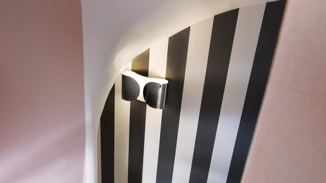 Dans les espaces de circulation et les parties communes, les couleurs pastel alternent avec des rayures noires et blanches.