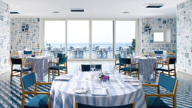 La somptueuse salle de restaurant de l’hôtel Parco dei Principi est baignée de lumière et de bleu jusqu’à la terrasse. Les murs, restaurés à l’identiques, sont décorés de céramiques artisanales, dessinées par Gio Ponti.