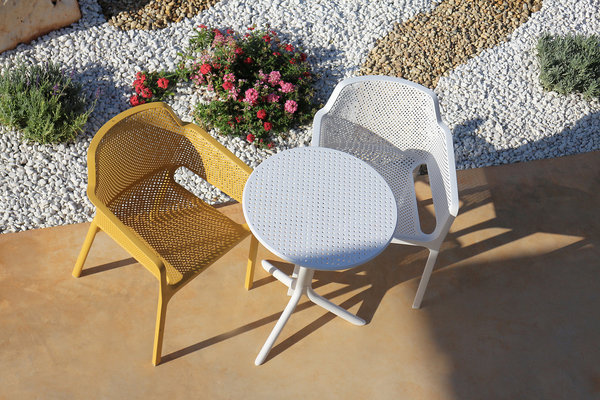 Seule ou en duo. La table ronde Spritz et les chaises élégantes de la collection Net complètent le mobilier outdoor.